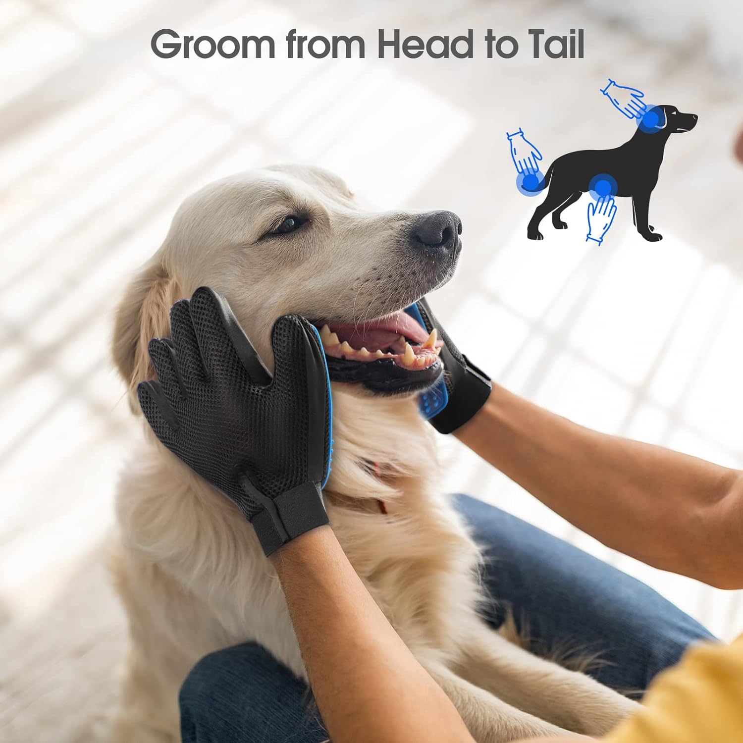Person using black and blue silicone grooming gloves on a happy golden retriever indoors
