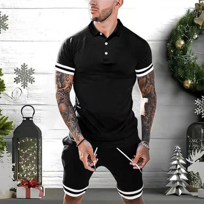 Man wearing black polo shirt and shorts with white stripes, standing in Christmas decor setting