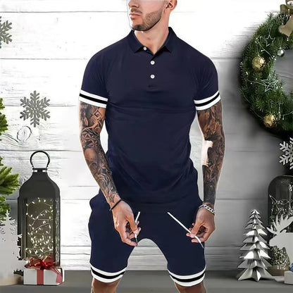 man wearing navy blue athletic polo shirt and shorts with white stripes, standing by Christmas decorations