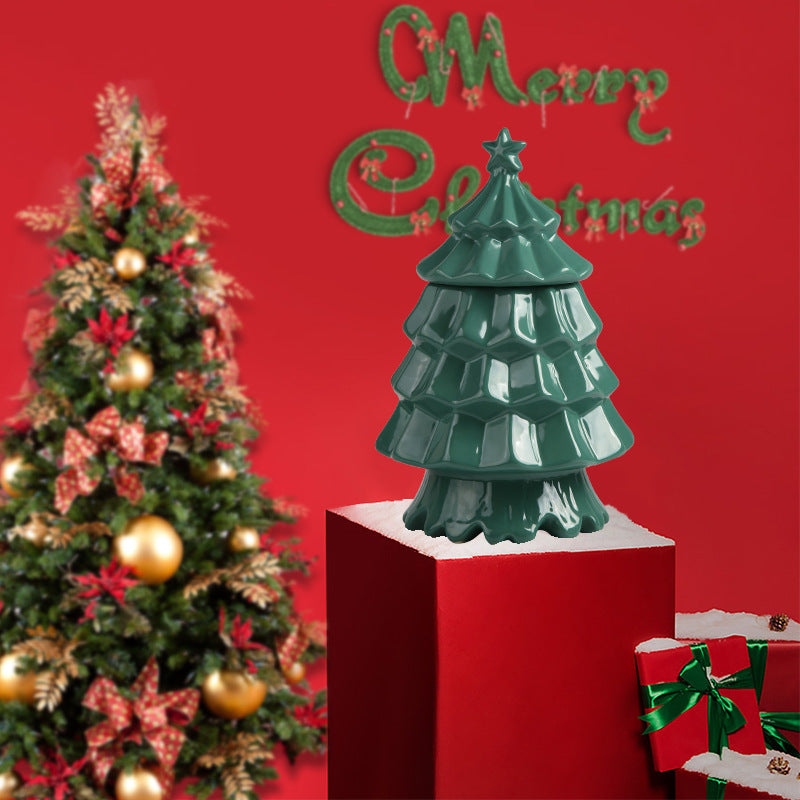 Green ceramic Christmas tree decor on red pedestal with decorated Christmas tree and gifts