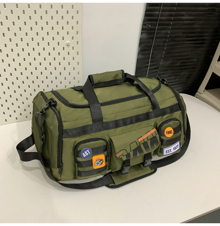 Green multifunctional travel duffel bag with black handles and patches on white table