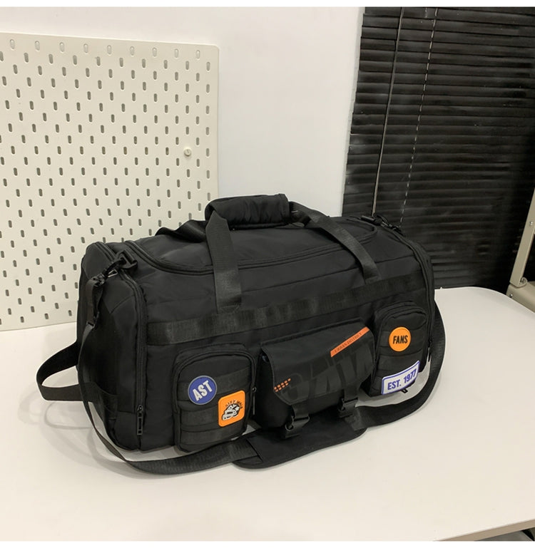 Black multifunctional travel duffel bag with multiple pockets and patches on white table