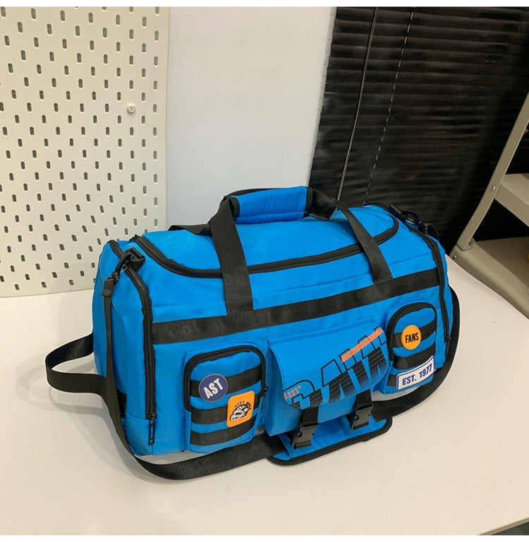 Blue large capacity travel duffel bag with black straps and multiple pockets on white surface