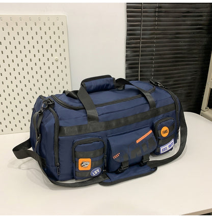Navy blue multifunctional travel duffle bag with black straps and front pockets with patches on white surface