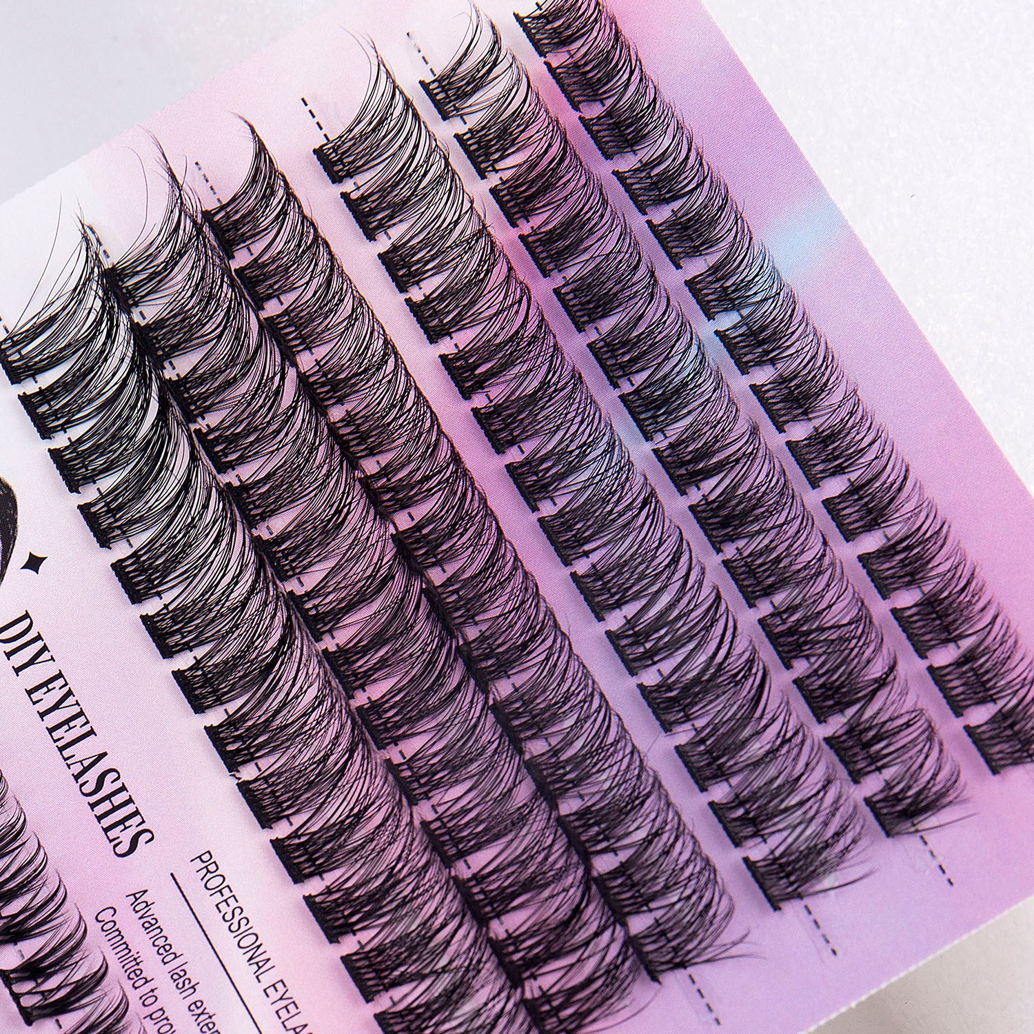 Segmented black DIY eyelash clusters on pink tray for natural lash extensions
