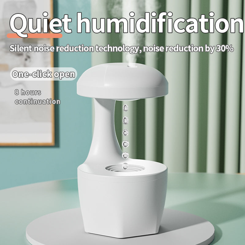 White anti-gravity humidifier with cool mist, water droplets suspended, on table with green curtains
