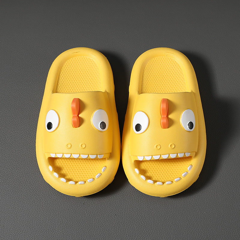 Yellow kids shark slippers with non-slip soles and fun face design on gray background