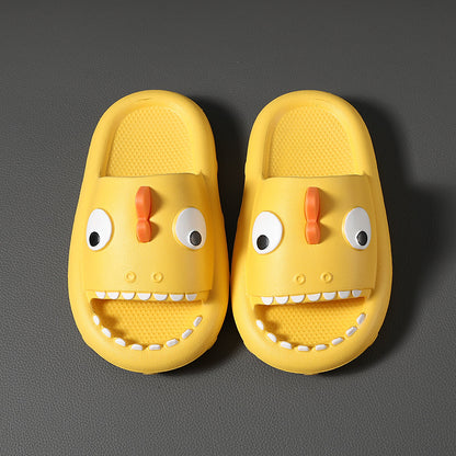 Yellow kids shark slippers with non-slip soles and fun face design on gray background