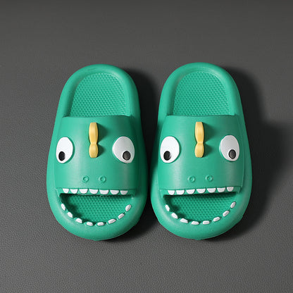 Green kids dinosaur slippers with big eyes and teeth, non-slip indoor shoes on dark surface