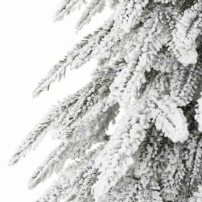 Close-up of frost-covered white artificial Christmas tree branches with snow-like texture