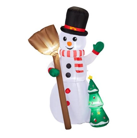 Inflatable Christmas snowman with black top hat, red and white scarf, holding a broom, next to a small lit Christmas tree