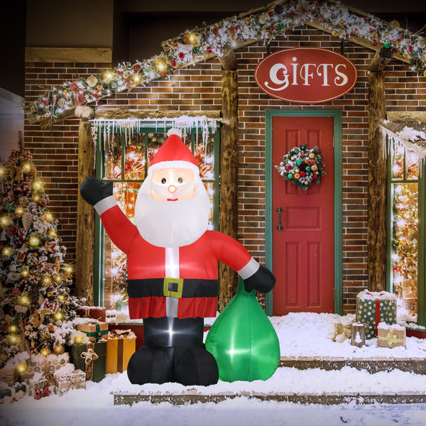 6ft inflatable Santa Claus with LED lights holding green sack in front of decorated gift shop door with snow