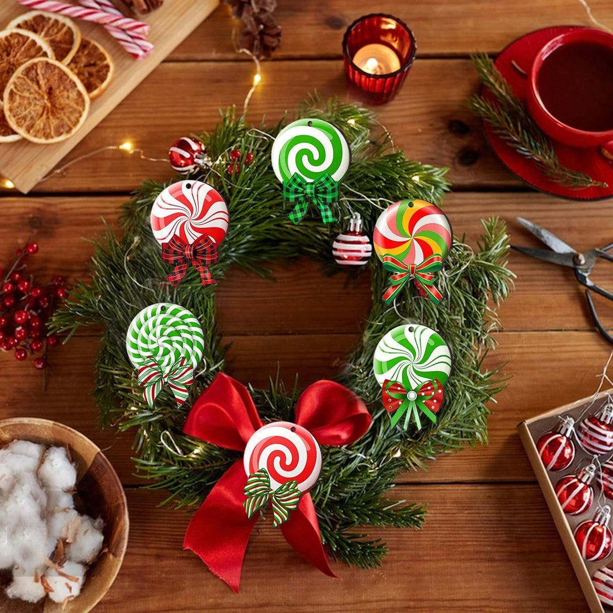 Festive Christmas wreath decorated with peppermint swirl ornaments and a large red bow on wooden table