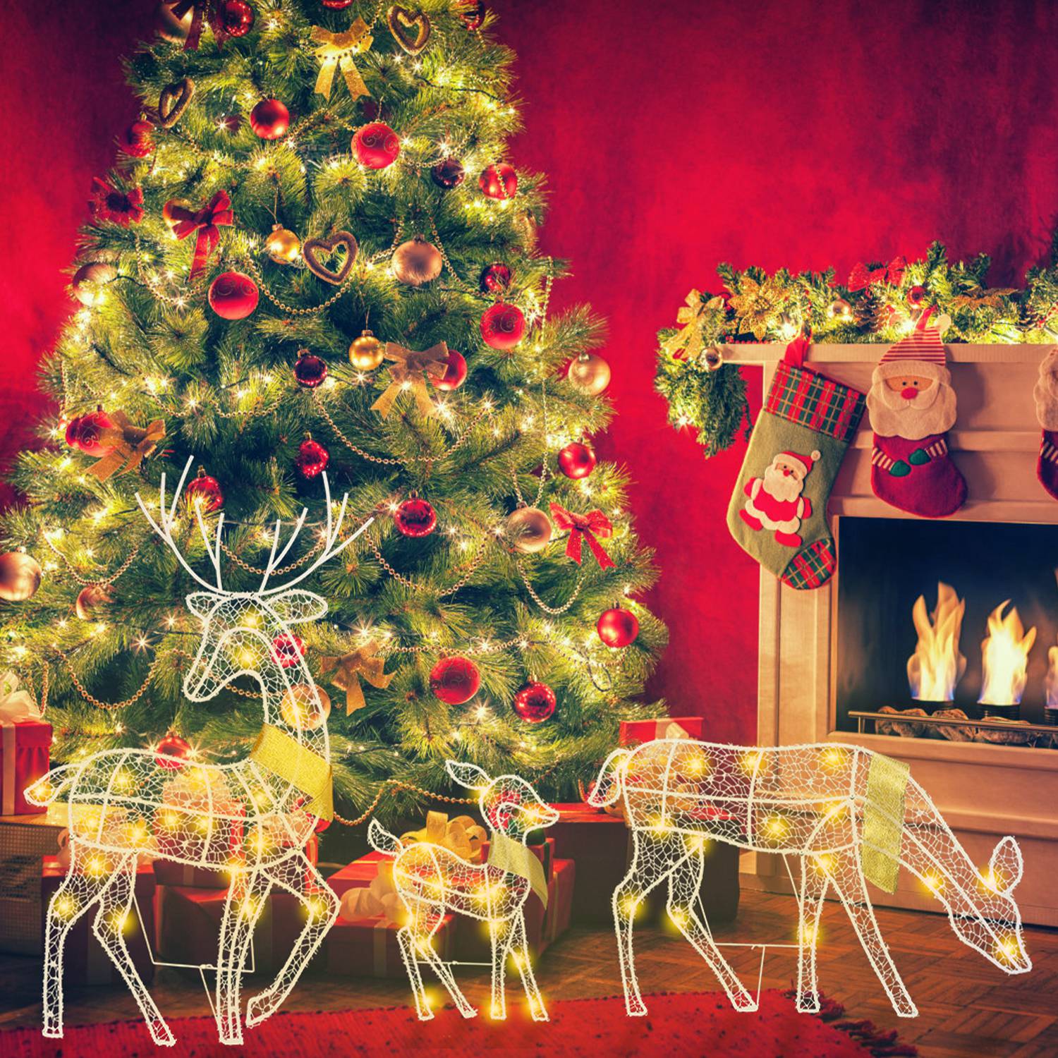 Lit wireframe reindeer family decorations by decorated Christmas tree and fireplace with stockings