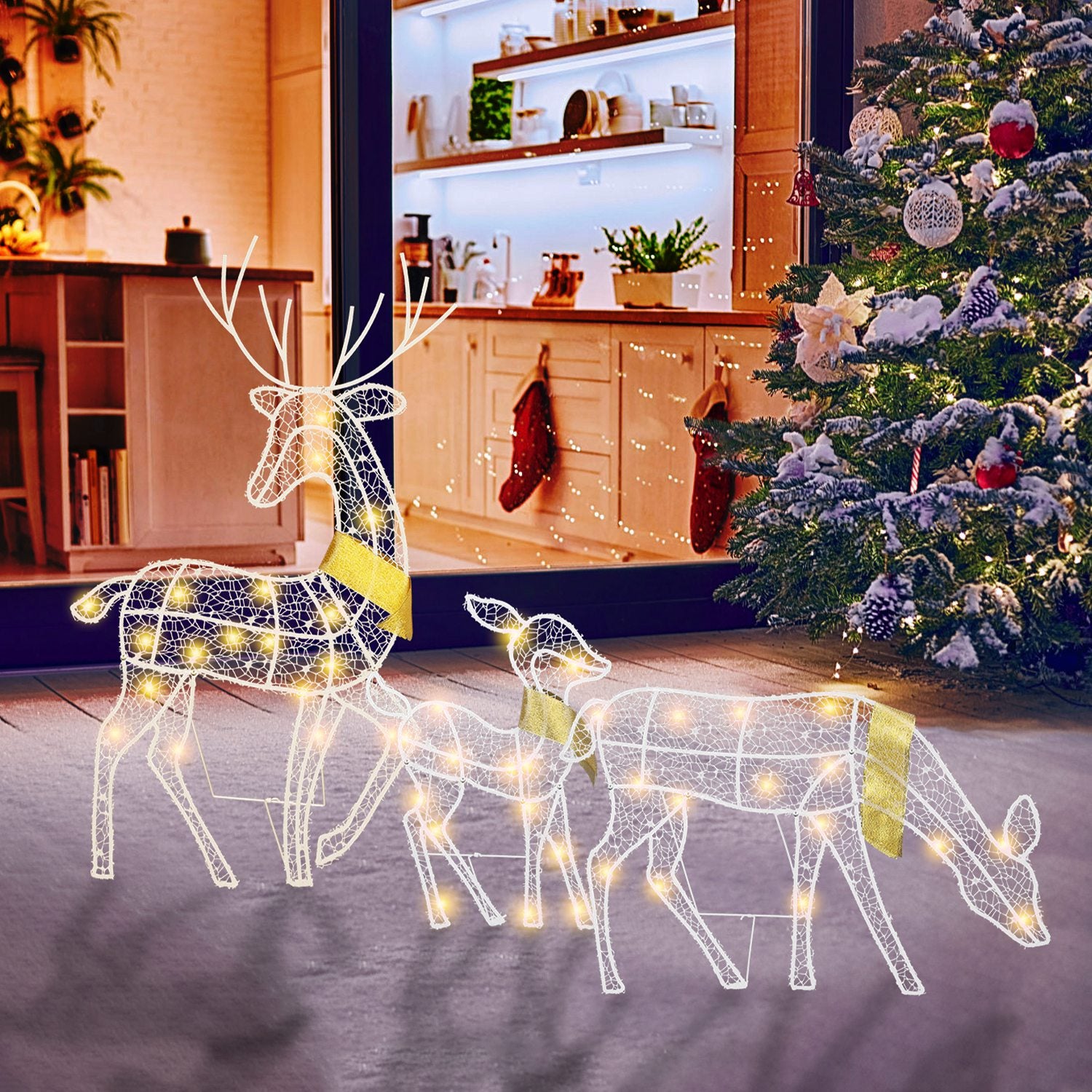 Lighted wireframe Christmas deer family decorations with warm yellow lights on snowy patio