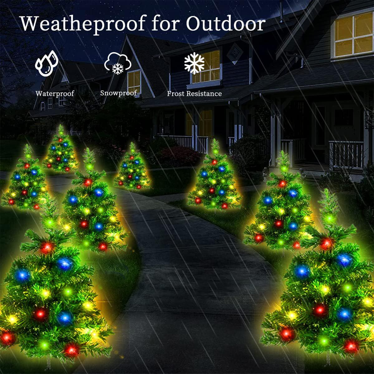 Outdoor solar-powered Christmas tree lights with multicolor LEDs lining a rainy pathway at night