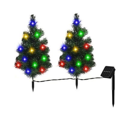 Two small artificial Christmas trees with multicolor LED lights connected to solar panel stake
