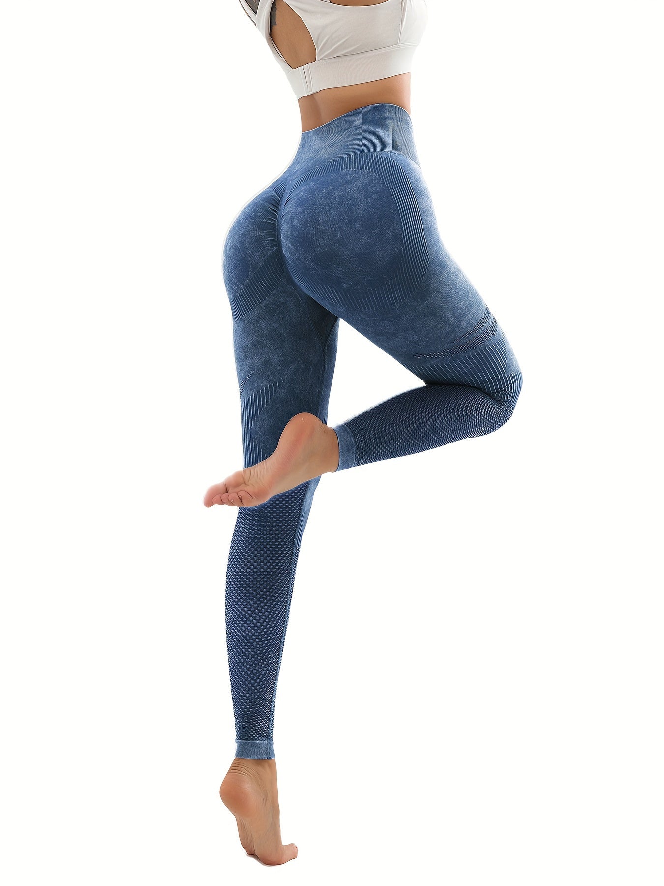 Woman wearing blue high-waisted seamless leggings with textured mesh panels, posing against white background