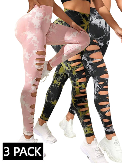 Three women wearing colorful tie-dye high-waist butt-lifting yoga leggings with multiple cut-outs, white sneakers