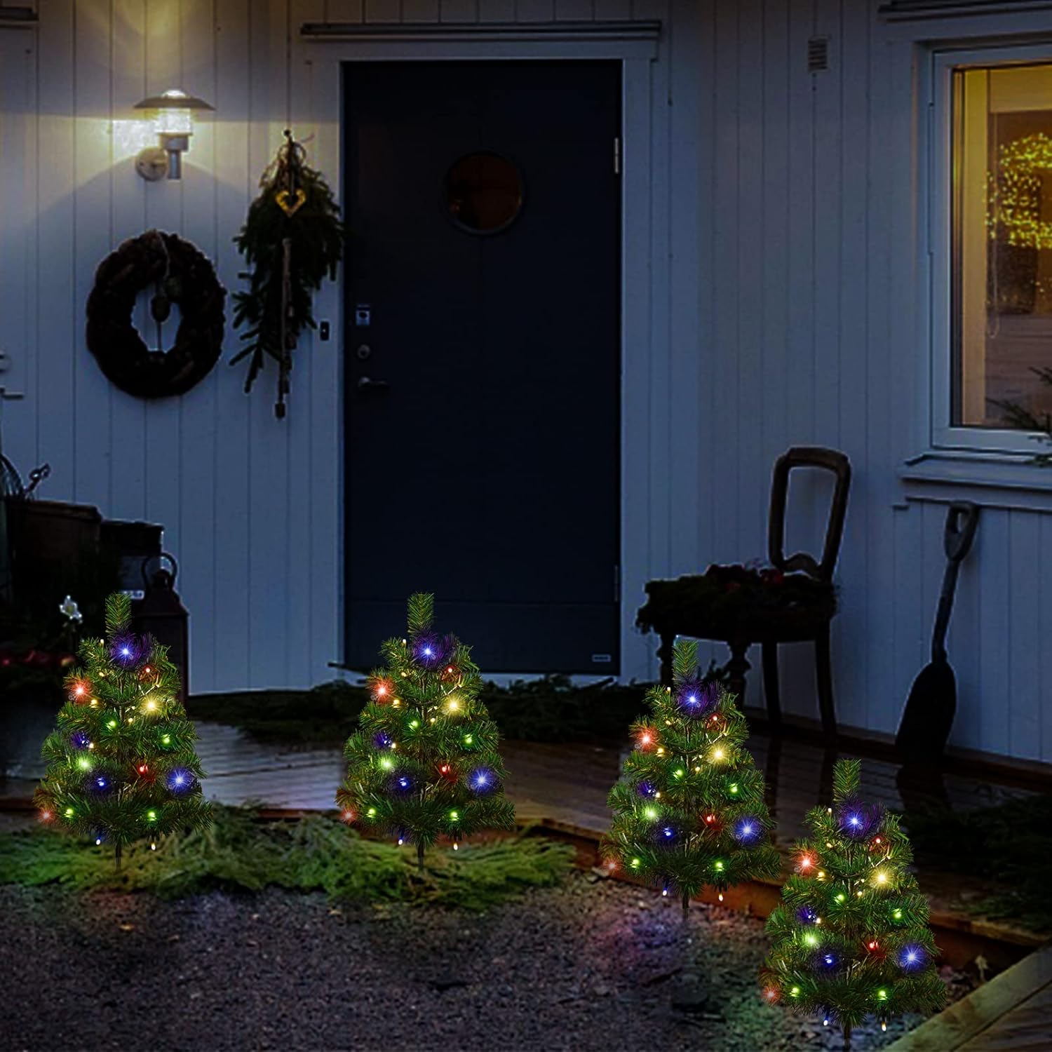 Small multicolored LED solar Christmas tree pathway lights in front yard at night