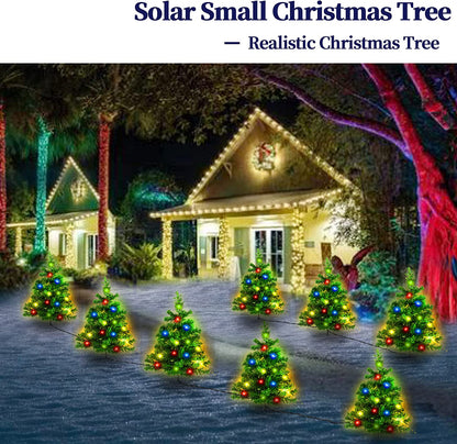 Pathway lined with multicolored solar LED Christmas tree lights outside a decorated house at night