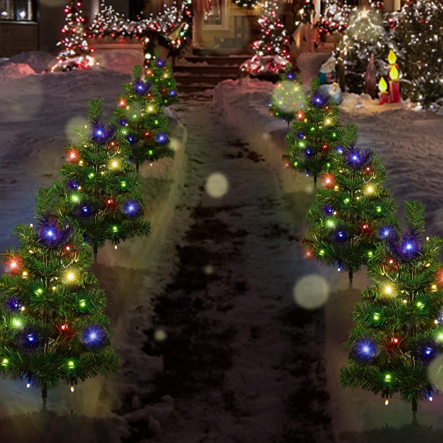 Snowy pathway lined with small multicolored LED-lit Christmas trees, festive outdoor holiday decor
