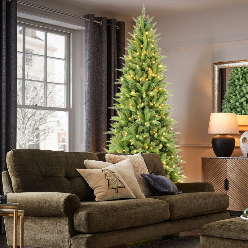 5-foot artificial Christmas tree with warm white LED lights in cozy living room with sofa and decorative pillows