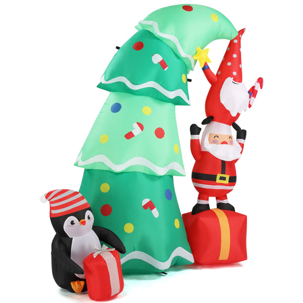 Inflatable Christmas decoration with a decorated tree, Santa holding a gnome, and a penguin with a gift