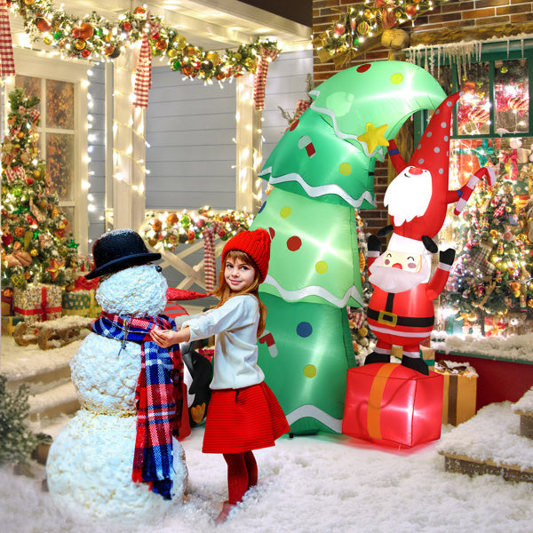 Girl in red hat and skirt building snowman in festive yard with Christmas inflatable tree and Santa decoration