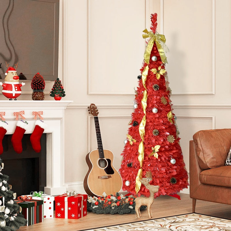 Red artificial Christmas tree decorated with gold ribbon, silver balls, and pine cones in cozy living room