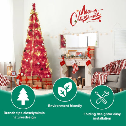 Red pre-lit Christmas tree with gold ribbons, ornaments, and gifts in cozy living room with fireplace and festive decor