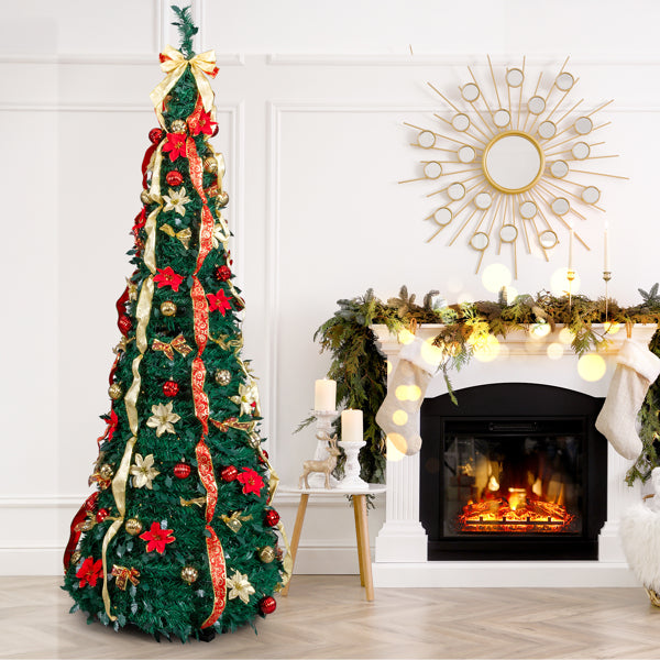 Tall pre-lit Christmas tree decorated with red and gold ornaments and ribbon next to a fireplace with holiday garland and stockings