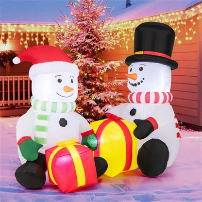 Inflatable Christmas snowmen with LED lights holding gift boxes in snowy yard with festive string lights