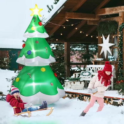 Children playing in snow near 6-9 ft inflatable LED Christmas tree with candy decorations and lit star