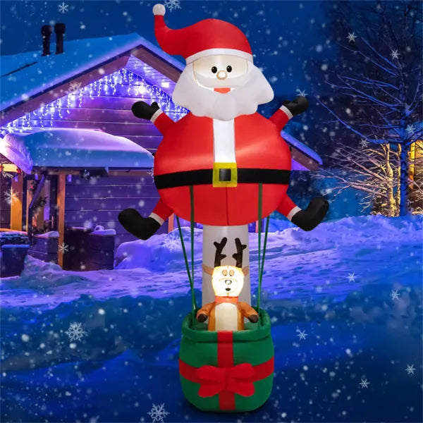 Inflatable Christmas decoration of Santa hot air balloon with reindeer in snow-covered yard at night