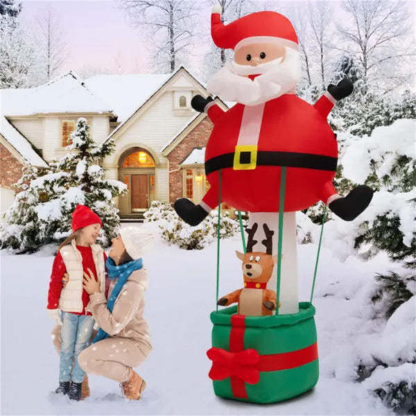 8ft inflatable Santa Claus and reindeer decoration in snowy yard with house, woman and child in winter clothes