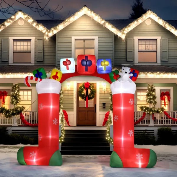 9ft inflatable Christmas stocking arch with gifts and polar bear in front of a decorated house with lights and wreaths