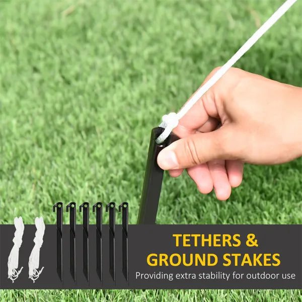 Hand inserting a black ground stake into green grass to secure a white tether rope for outdoor stability