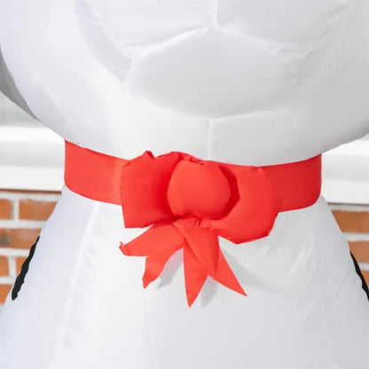 Close-up of white inflatable holiday decoration with large red bow on brick background