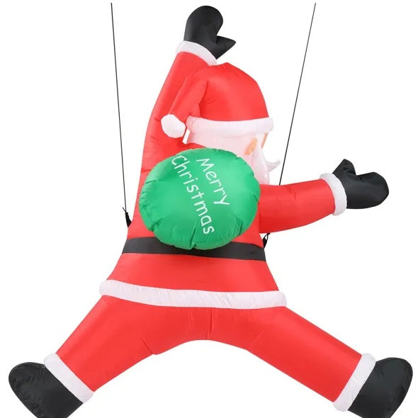 Inflatable Santa Claus decoration in red suit with black gloves and boots, holding a green Merry Christmas sack