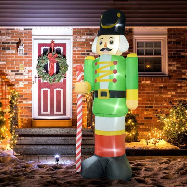 Inflatable nutcracker soldier Christmas yard decoration with LED lights in front of a house entrance with wreath and holiday lights