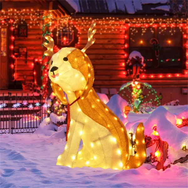 Lighted Christmas dog decoration with antlers in snow-covered yard decorated with colorful holiday lights