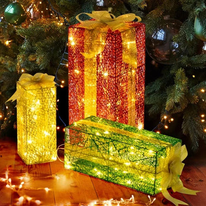 Set of three lighted Christmas gift boxes in red, yellow, and green with warm white LED lights under a decorated tree