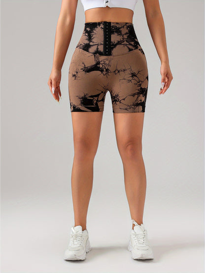 Woman wearing high waist black and brown tie-dye scrunch butt lifting shorts with white sneakers