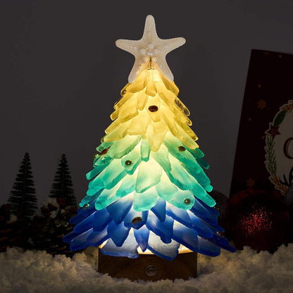 Mini LED Christmas tree ornament with blue and green sea glass shards topped with a starfish, glowing warmly