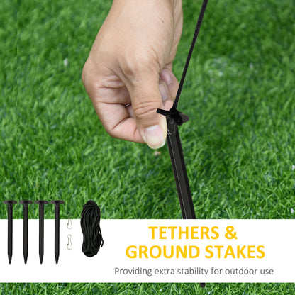 Hand tying black tether rope to ground stake on green grass for outdoor stability