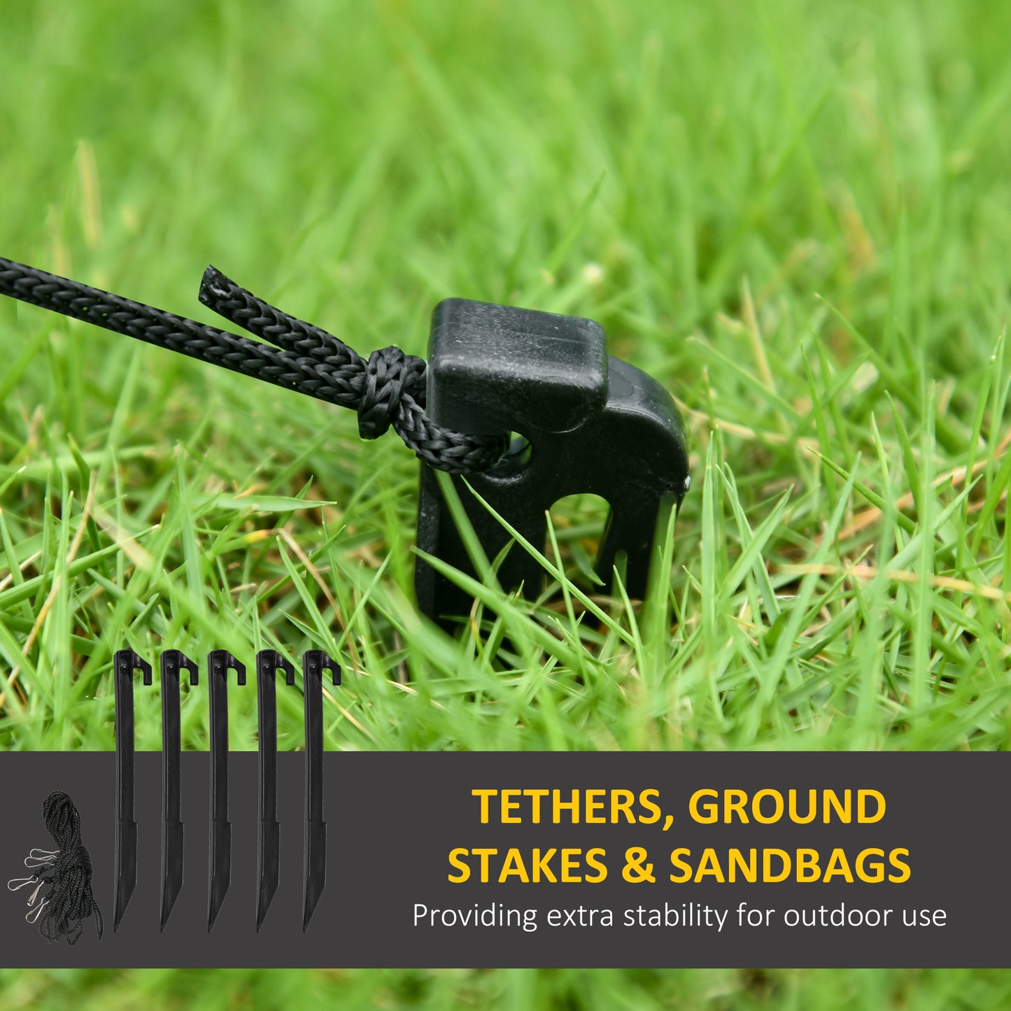 Black ground stake with black rope tether secured in green grass for outdoor stability