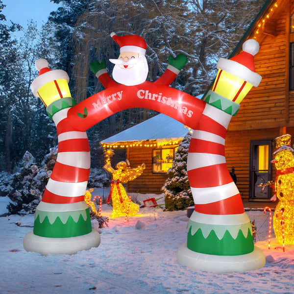 Red and white striped inflatable Christmas arch with Santa and lanterns, snowy yard and wooden house