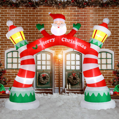 Inflatable Christmas arch with Santa figure, red and white stripes, and yellow lanterns in snowy festive scene