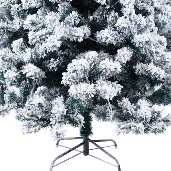 Close-up of a flocked artificial Christmas tree with dense white snow-covered branches and metal stand